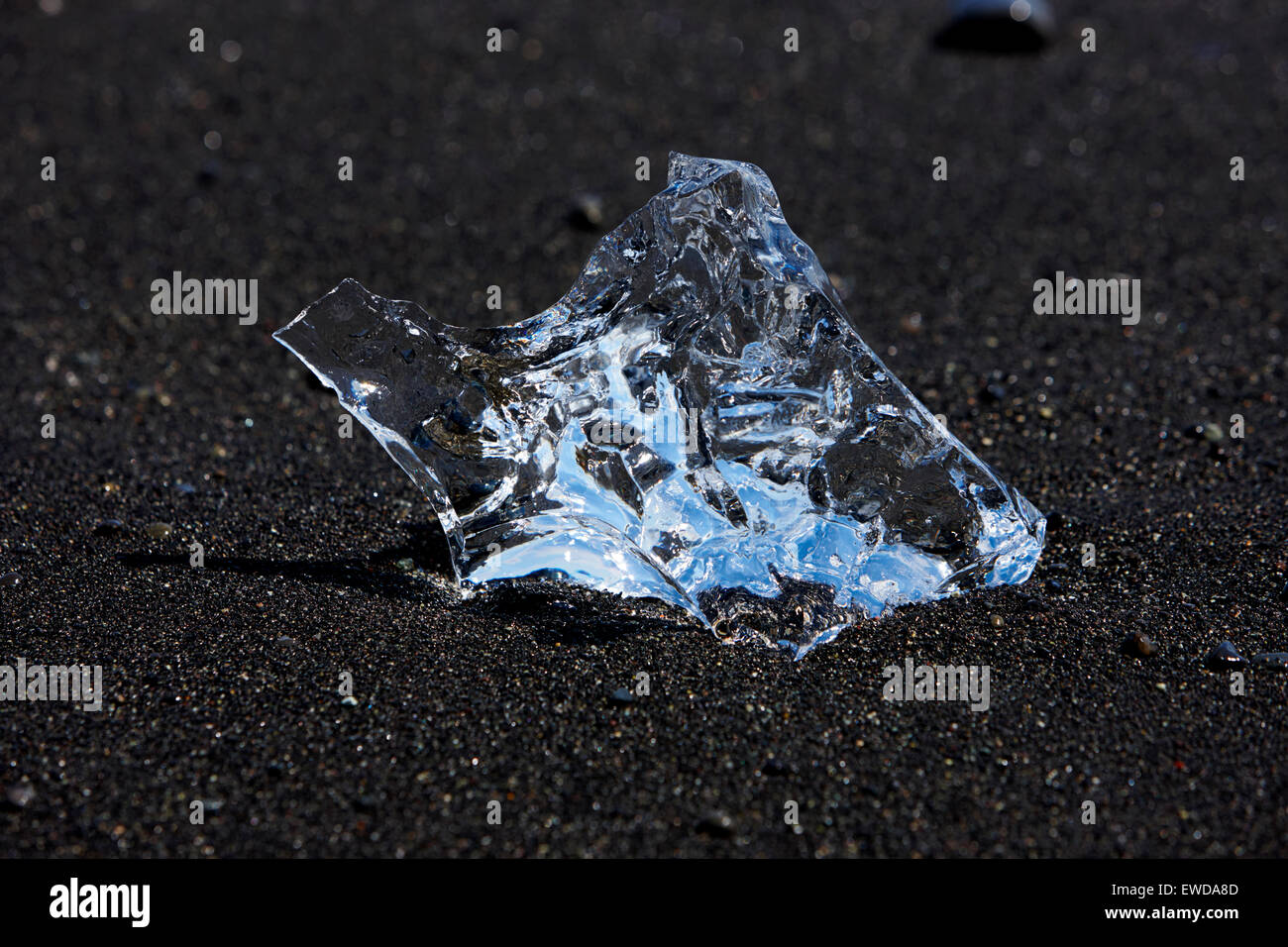 Lave-glace bleu clair jusqu'à la plage de sable noir à l'Islande Jokulsarlon Banque D'Images