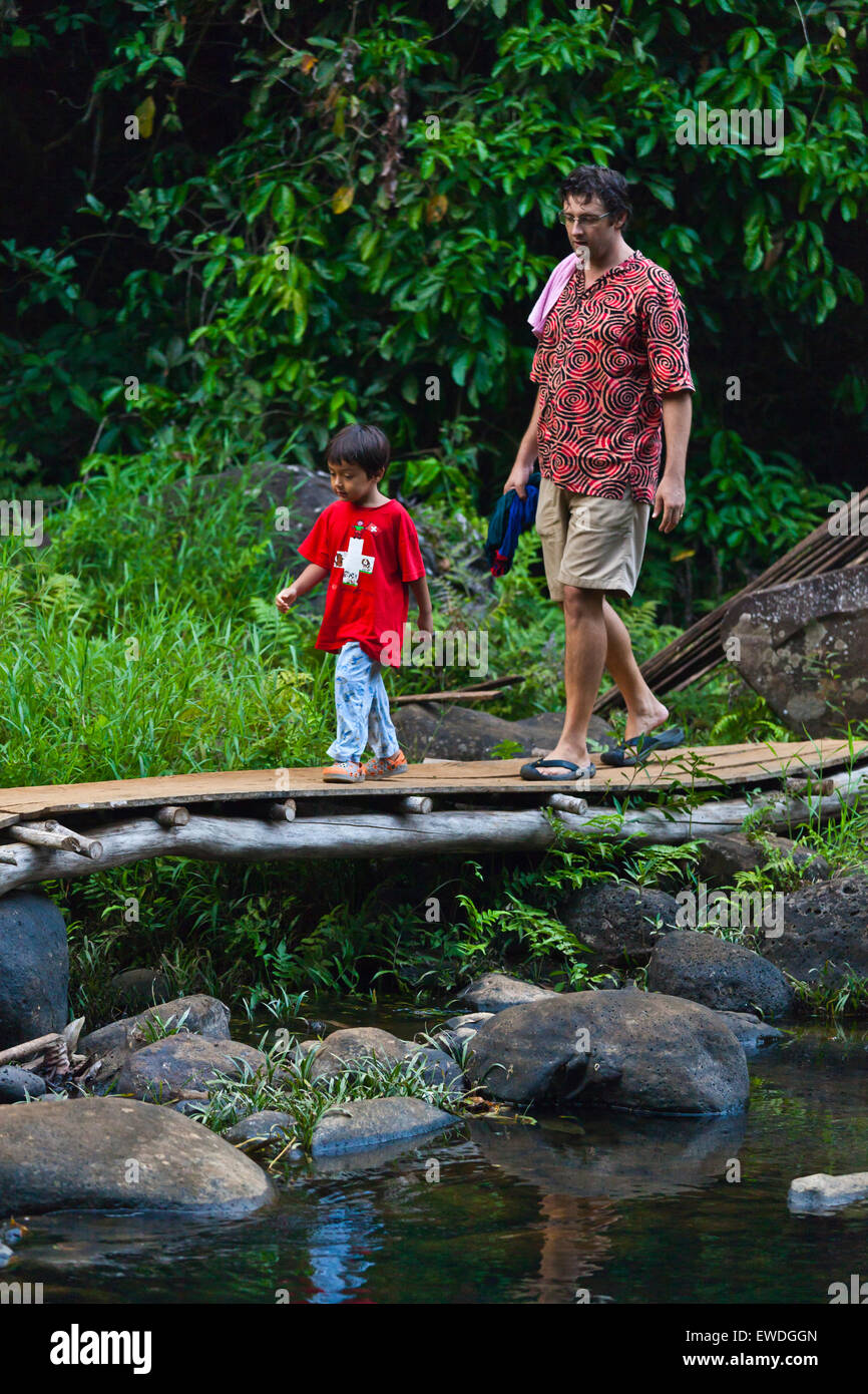 Un père et son fils à pied ci-dessous CHAMPEE CASCADE située sur le PLATEAU DES BOLAVENS près de Pakse, LAOS DU SUD - MR Banque D'Images