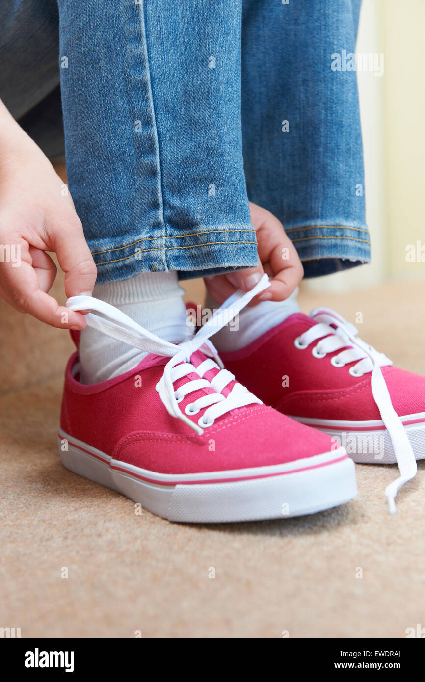 Girl Sitting on Stairs attacher ses lacets Banque D'Images