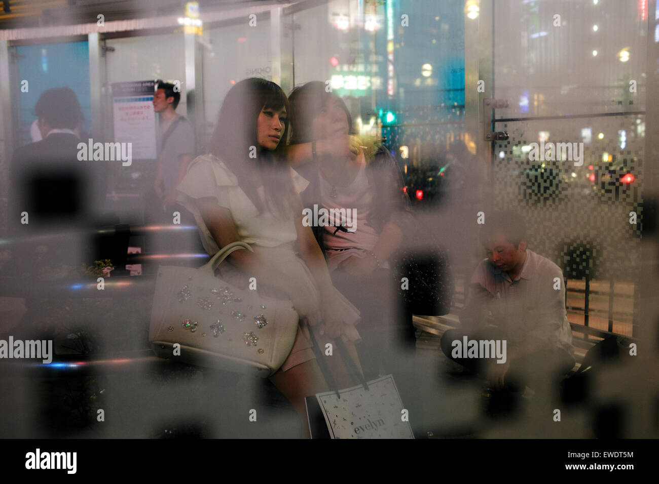 Yong femmes à la nuit dans une zone fumeurs à Shinjuku, Tokyo, Japon Banque D'Images