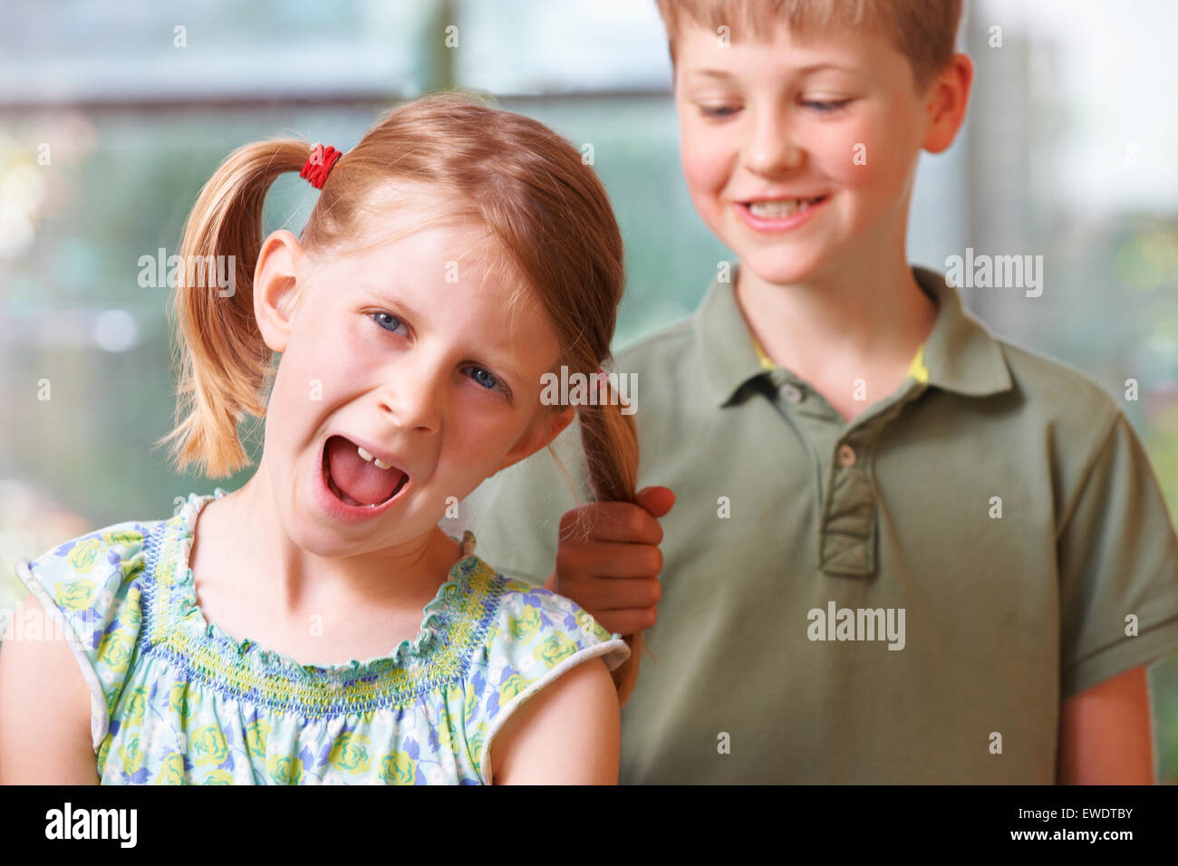 Garçon Fille en tirant les cheveux de l'intimidation Banque D'Images