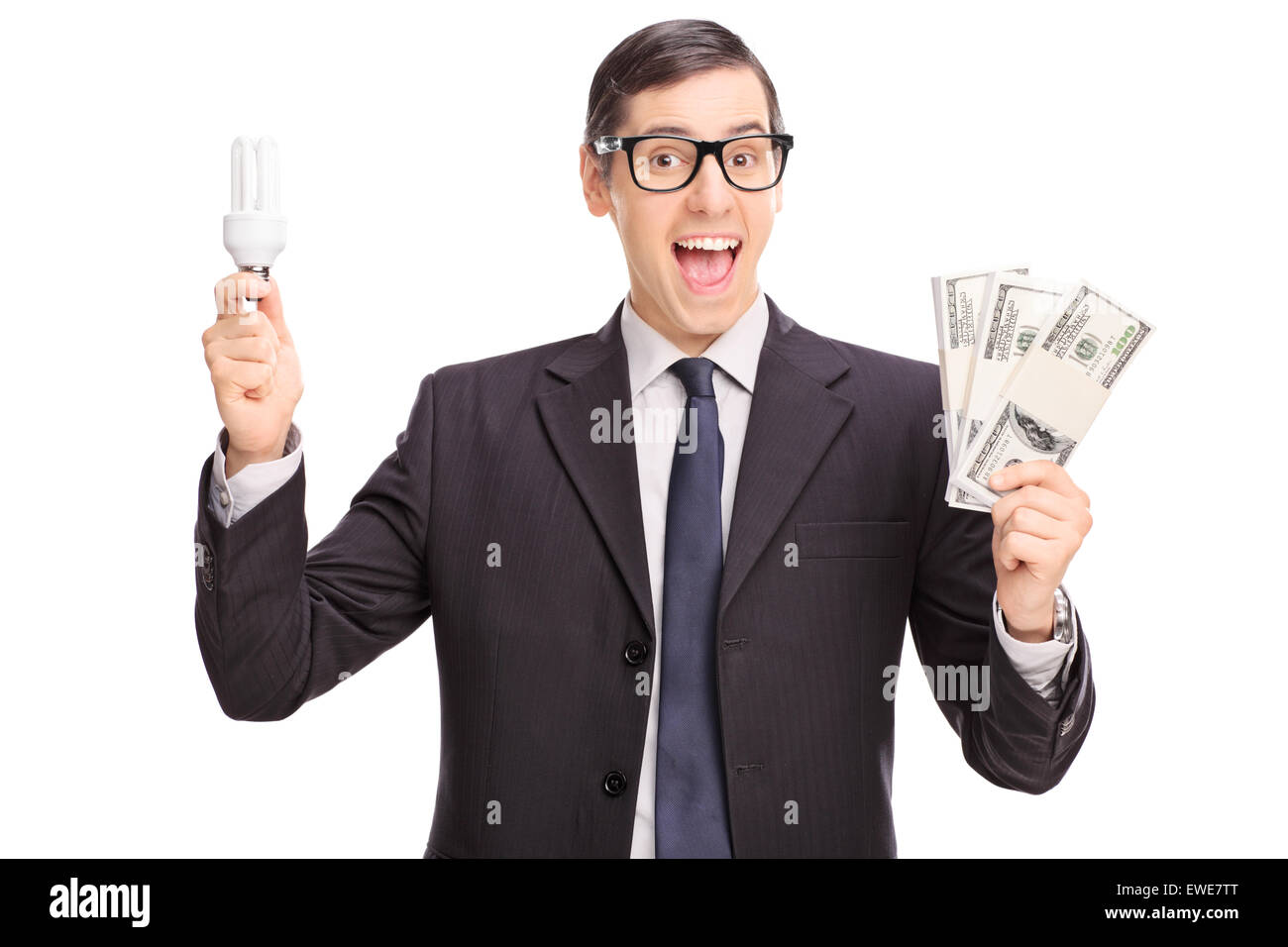Cheerful young man holding une ampoule à économie d'énergie et trois piles d'argent isolé sur fond blanc Banque D'Images