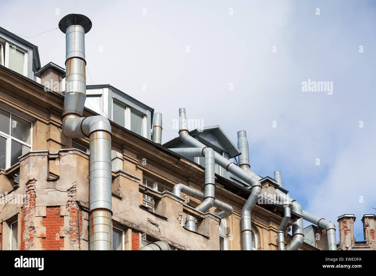 Nouvelles lucarnes dans le vieux toit de maison vivant avec des tuyaux de ventilation, de l'architecture high-tech Banque D'Images
