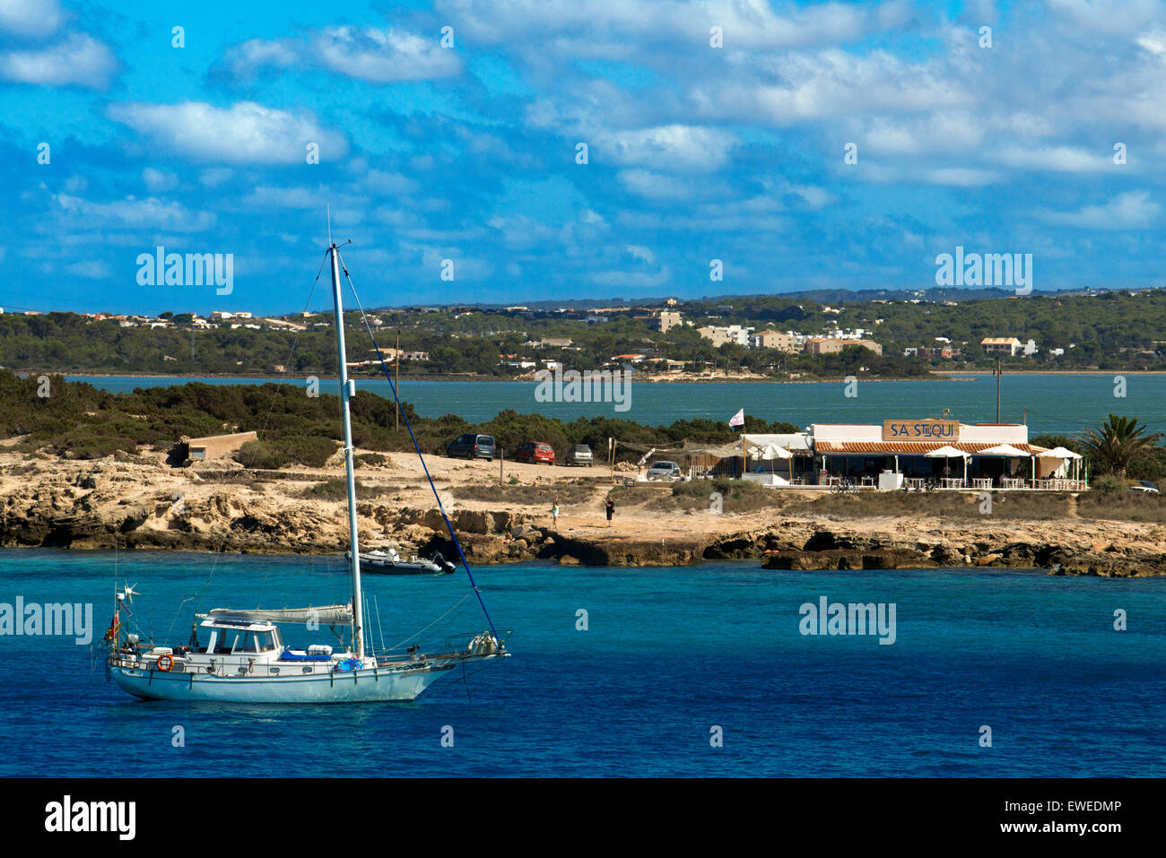 Sa Sequi Restaurant, plage Cala Savina, Formentera island, Îles Baléares, Espagne. La cuisine méditerranéenne. Un yacht de voile. Banque D'Images
