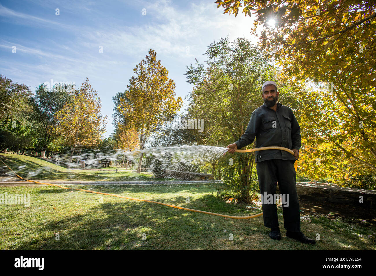 Travailleur Afghan watering plants in park dans le jardin de Babur, Kaboul, Afghanistan Banque D'Images