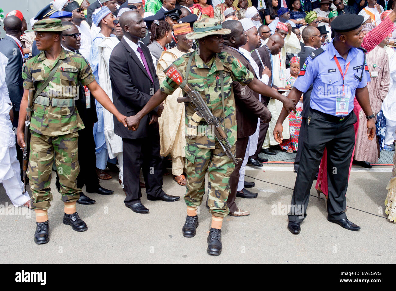 Le personnel de sécurité tenir la main pour former une chaîne humaine comme le Président nigérian Goodluck Jonathan puissance transférée au président élu Muhammadu Buhari au cours d'une cérémonie d'inauguration - assisté par le secrétaire d'Etat John Kerry et d'autres membres d'une délégation représentant le président Obama - à Eagle Square, à Abuja, Nigéria, le 29 mai 2015. Banque D'Images