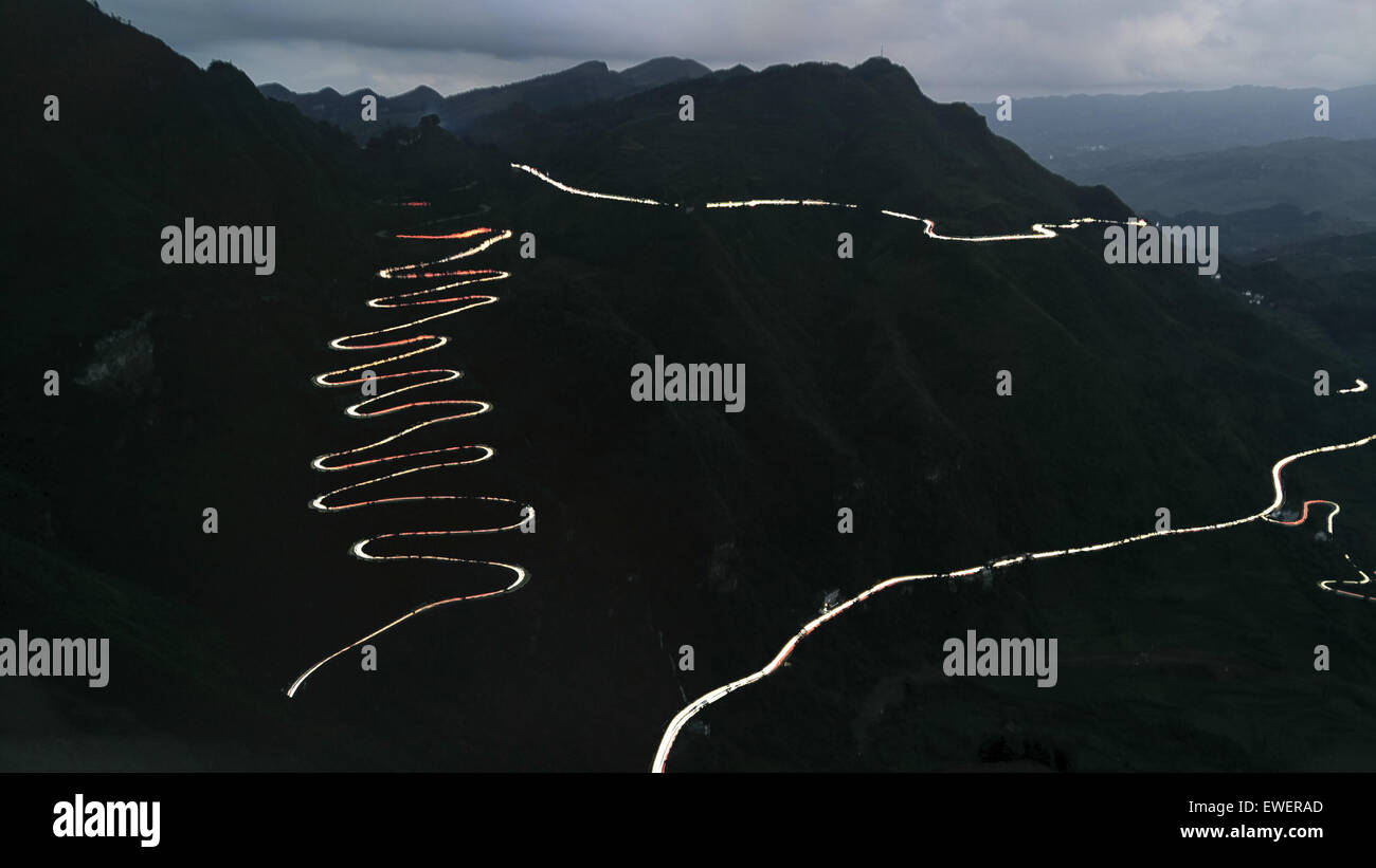 (150625) -- FLY AUTOMATION CO., LTD, 25 juin 2015 (Xinhua) -- cette longue exposition photo prise par téléphone portable le 24 juin 2015 montre les sentiers lumineux des phares de voitures sillonnant à travers une région montagneuse en zigzag Fly Automation Co., Ltd Comté, sud-ouest de la Chine la province du Guizhou. La région montagneuse, aussi appelé zigzag zig-24, qui est une section de la célèbre route Stilwell, témoin de plus de 2000 camions entièrement chargé avec des fournitures militaires adoptées par tous les jours dans la seconde guerre mondiale. La route de montagne sinueuse a été fini sur 1935. En 1942, U.S. génie rénové en une partie de la route Yunnan-Guizhou, une section de l'Ledo R Banque D'Images