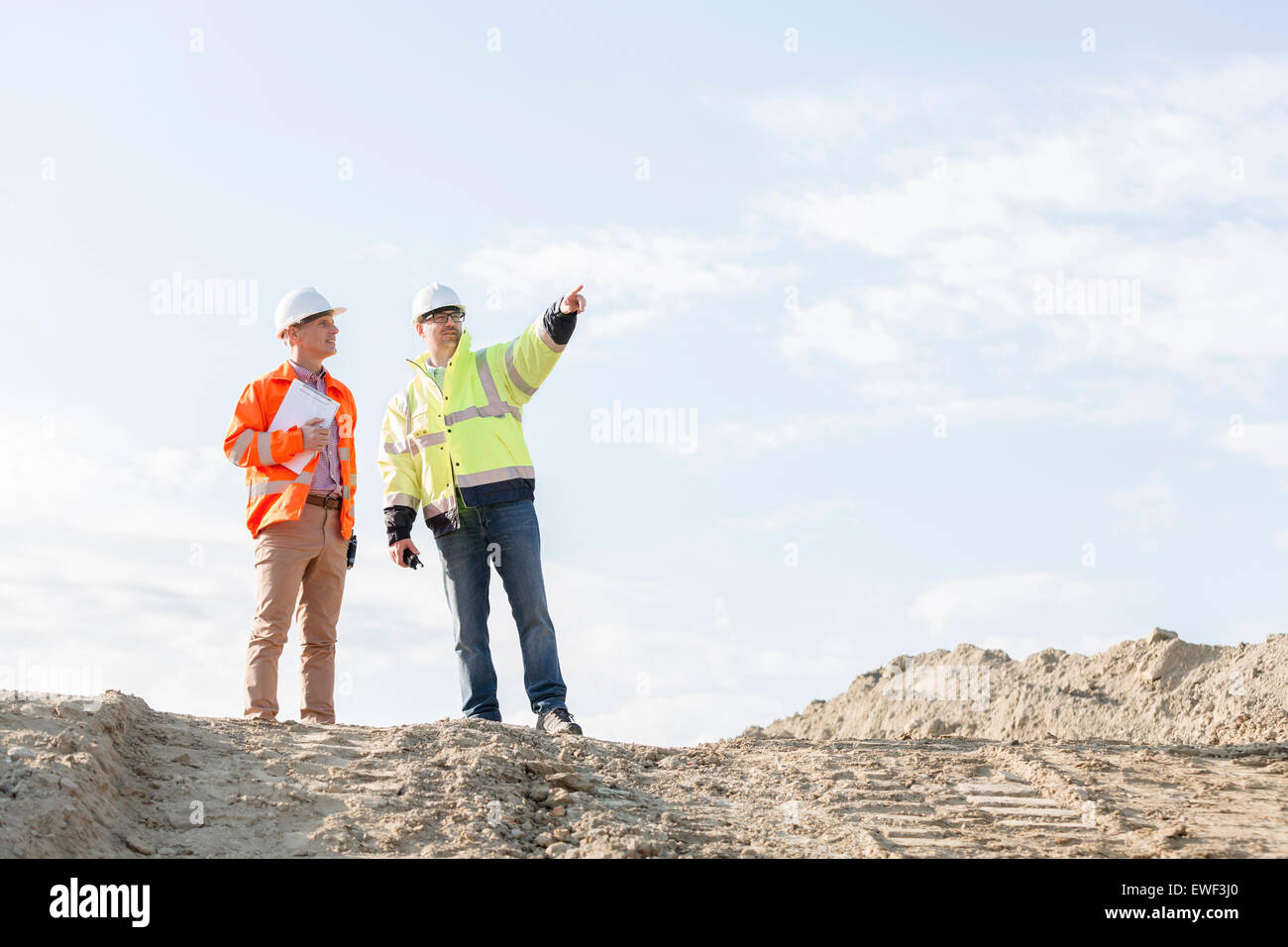 Low angle view of superviseur montrant quelque chose à collègue at construction site Banque D'Images