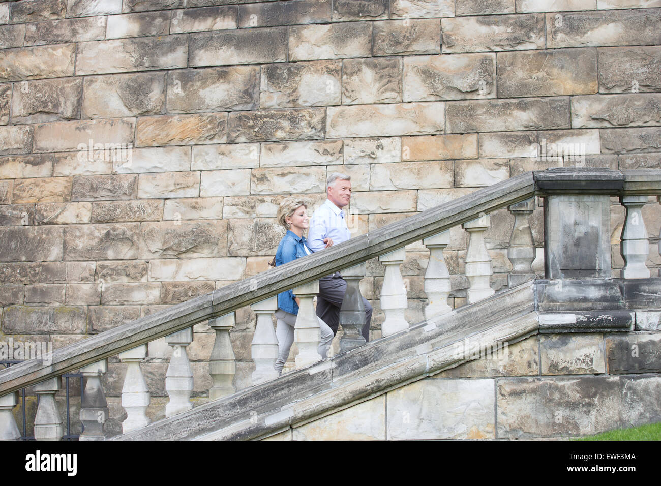 Vue latérale du couple climbing steps à l'extérieur de l'ancien bâtiment Banque D'Images