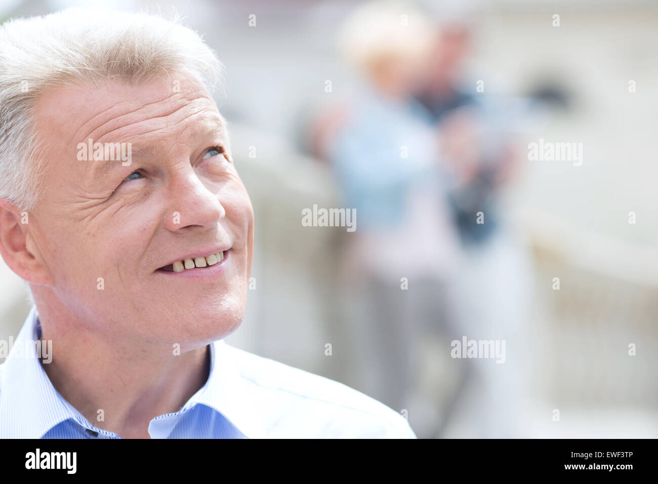Close-up of smiling man sitting outdoors Banque D'Images