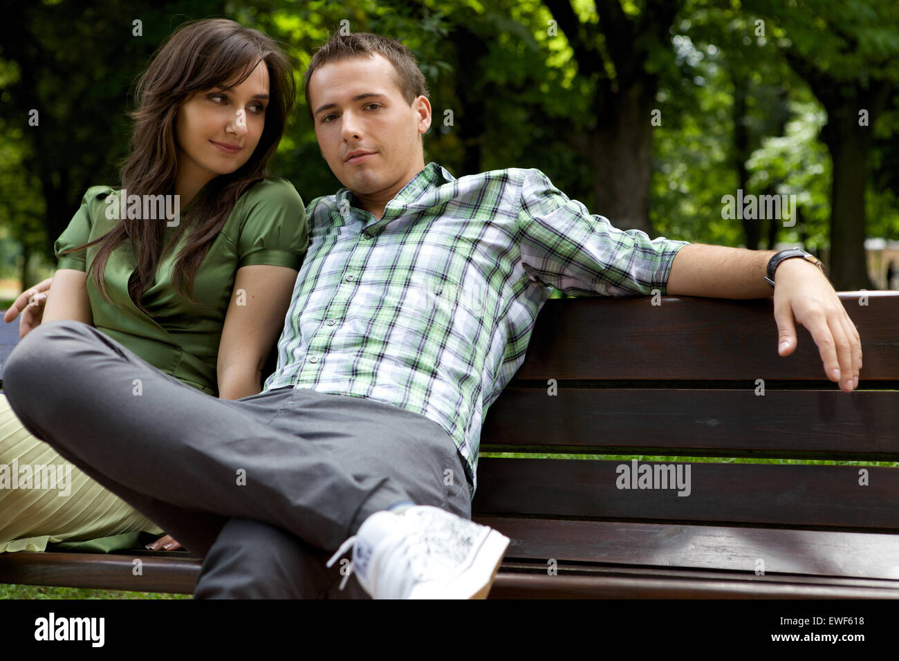 Young couple sitting on bench Banque D'Images
