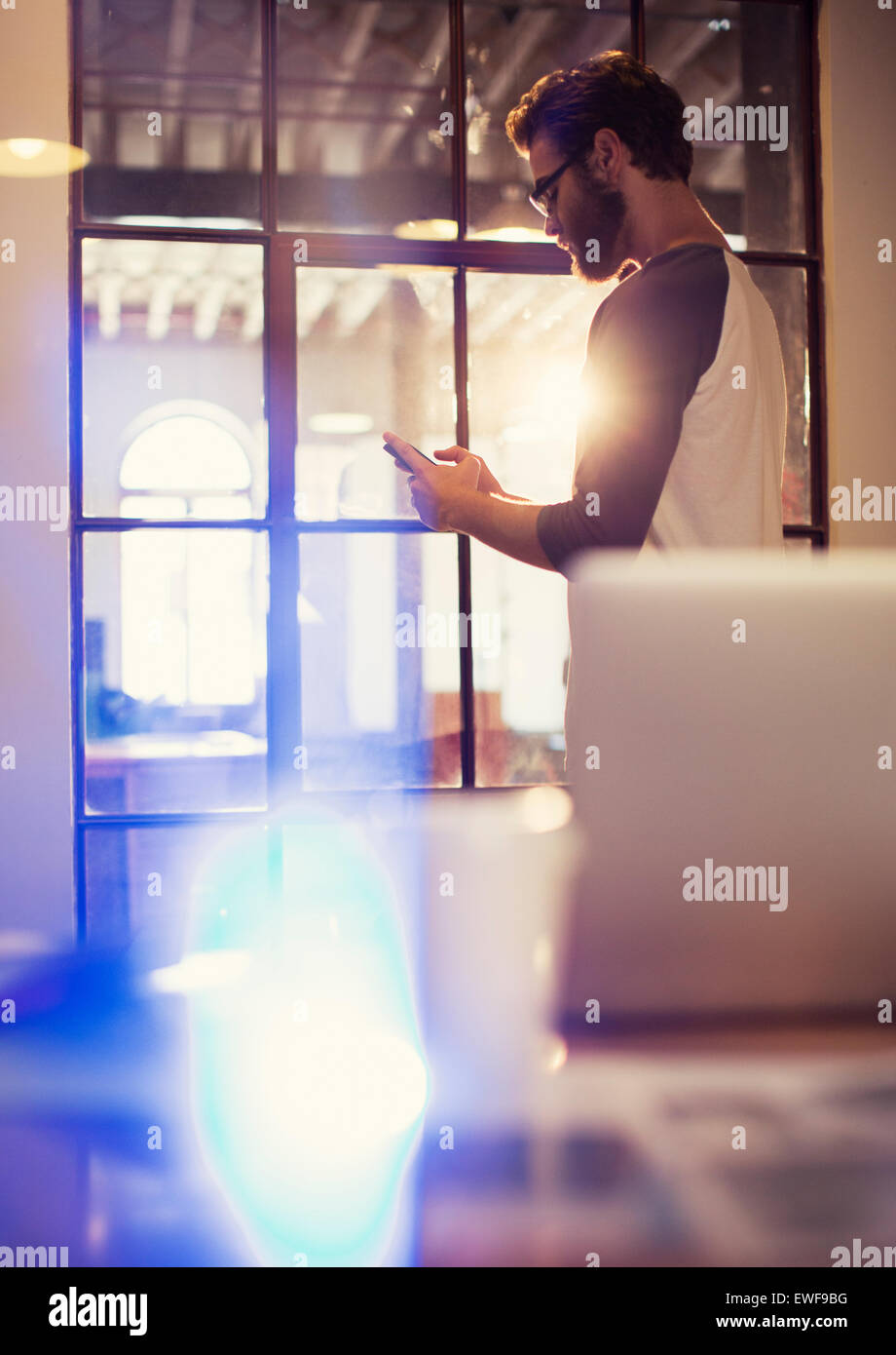 Businessman texting with cell phone in office Banque D'Images