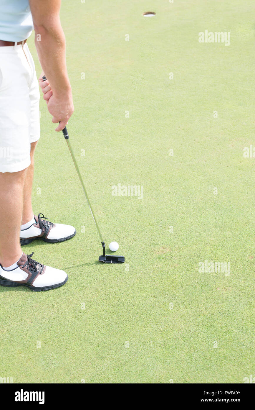 La section basse de mid-adult man playing golf Banque D'Images