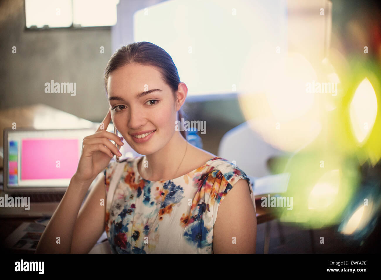 Smiling businesswoman talking on cell phone in office Banque D'Images