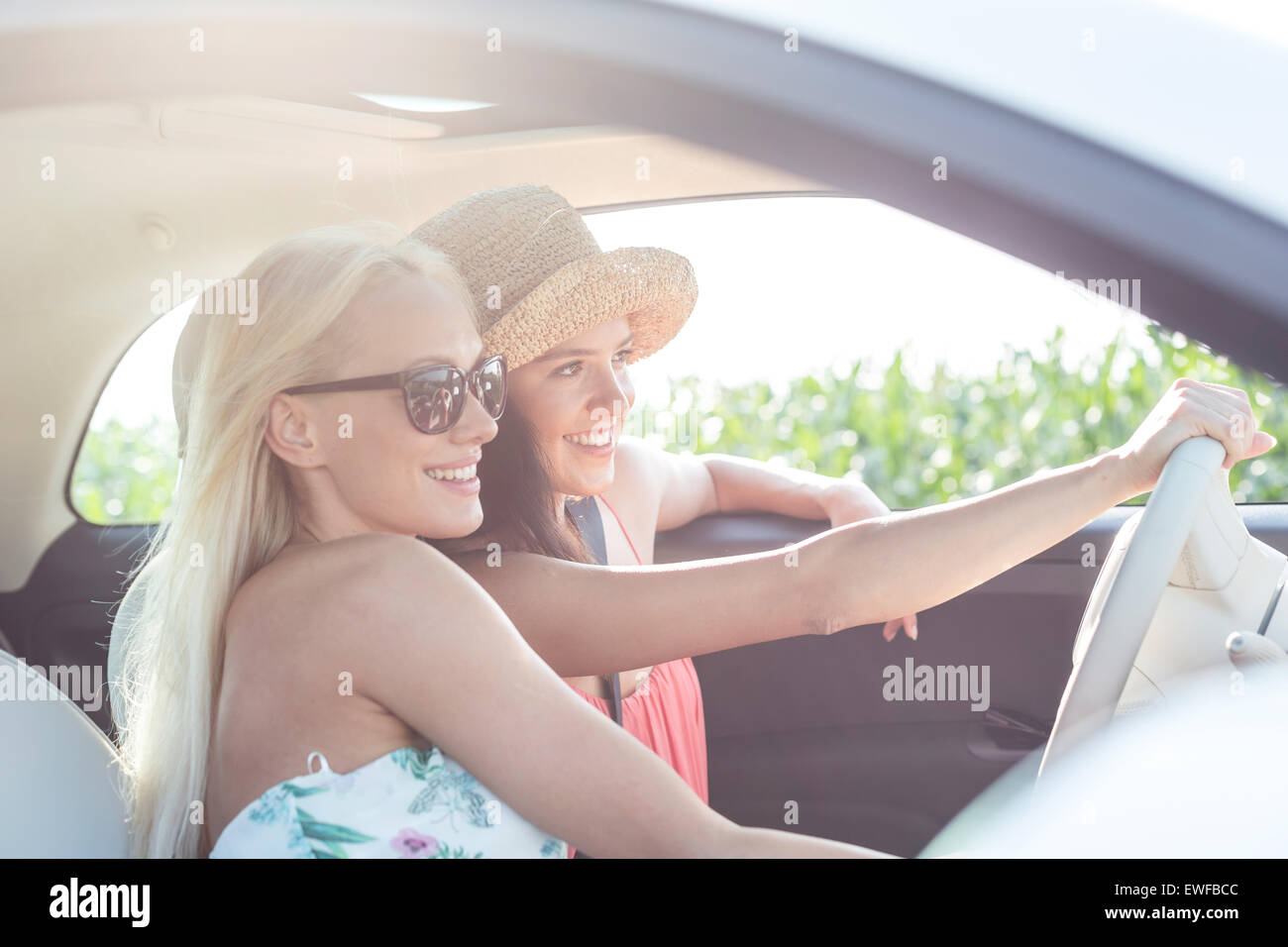 Happy female friends enjoying en voiture sur sunny day Banque D'Images