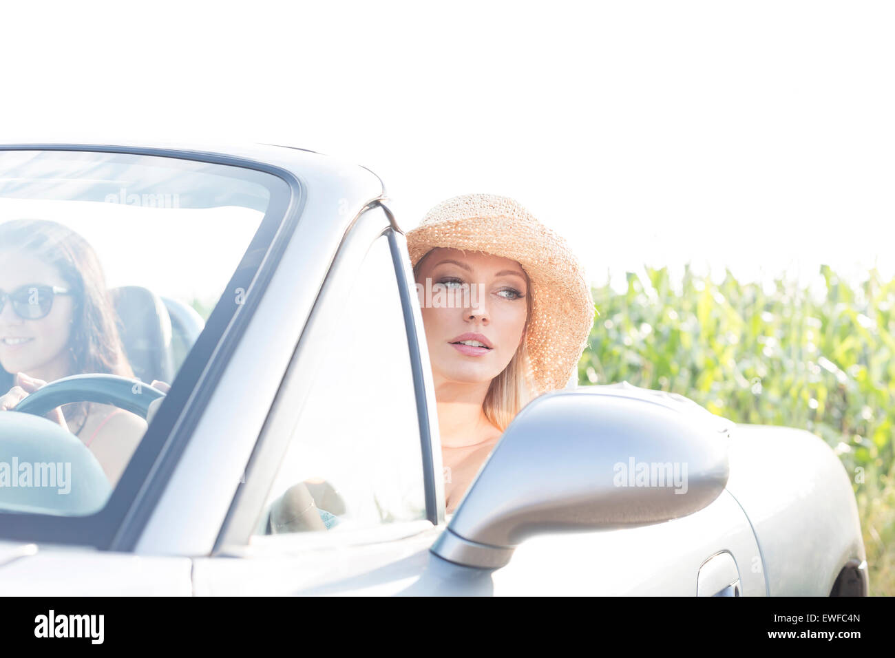 Woman sitting in convertible avec amie sur sunny day Banque D'Images