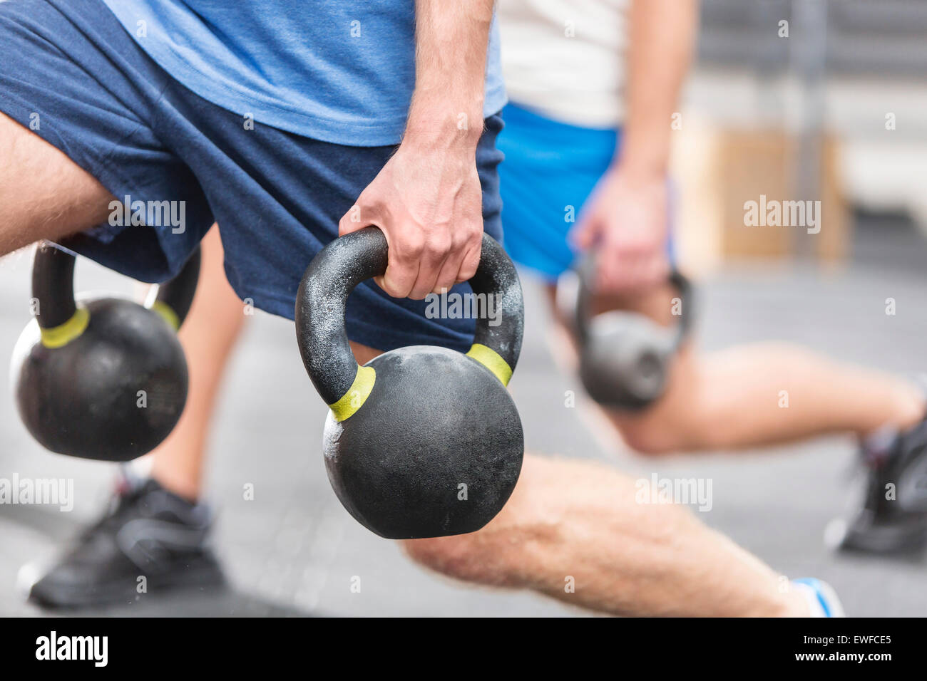 Portrait d'hommes levée kettlebells à crossfit gym Banque D'Images