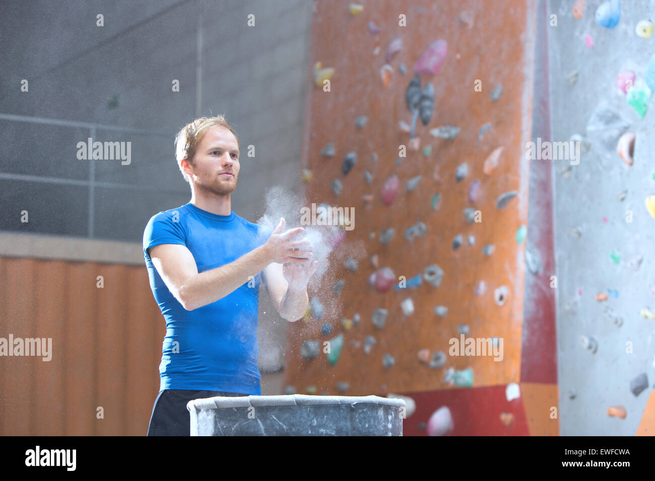 Homme confiant poudre par mur d'escalade en salle de sport crossfit Banque D'Images