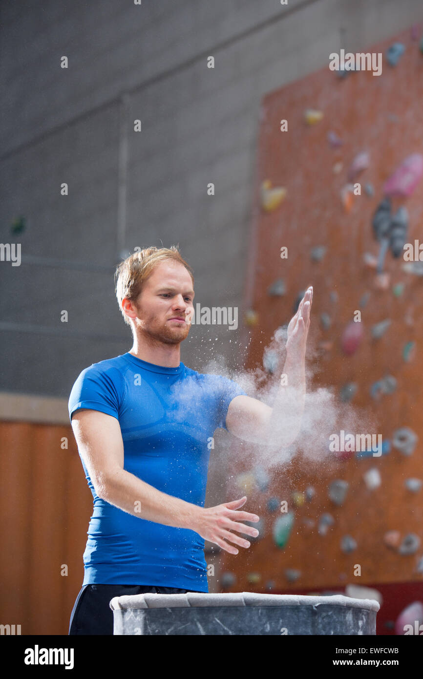 Man dusting poudre en mur d'escalade en salle de sport crossfit Banque D'Images