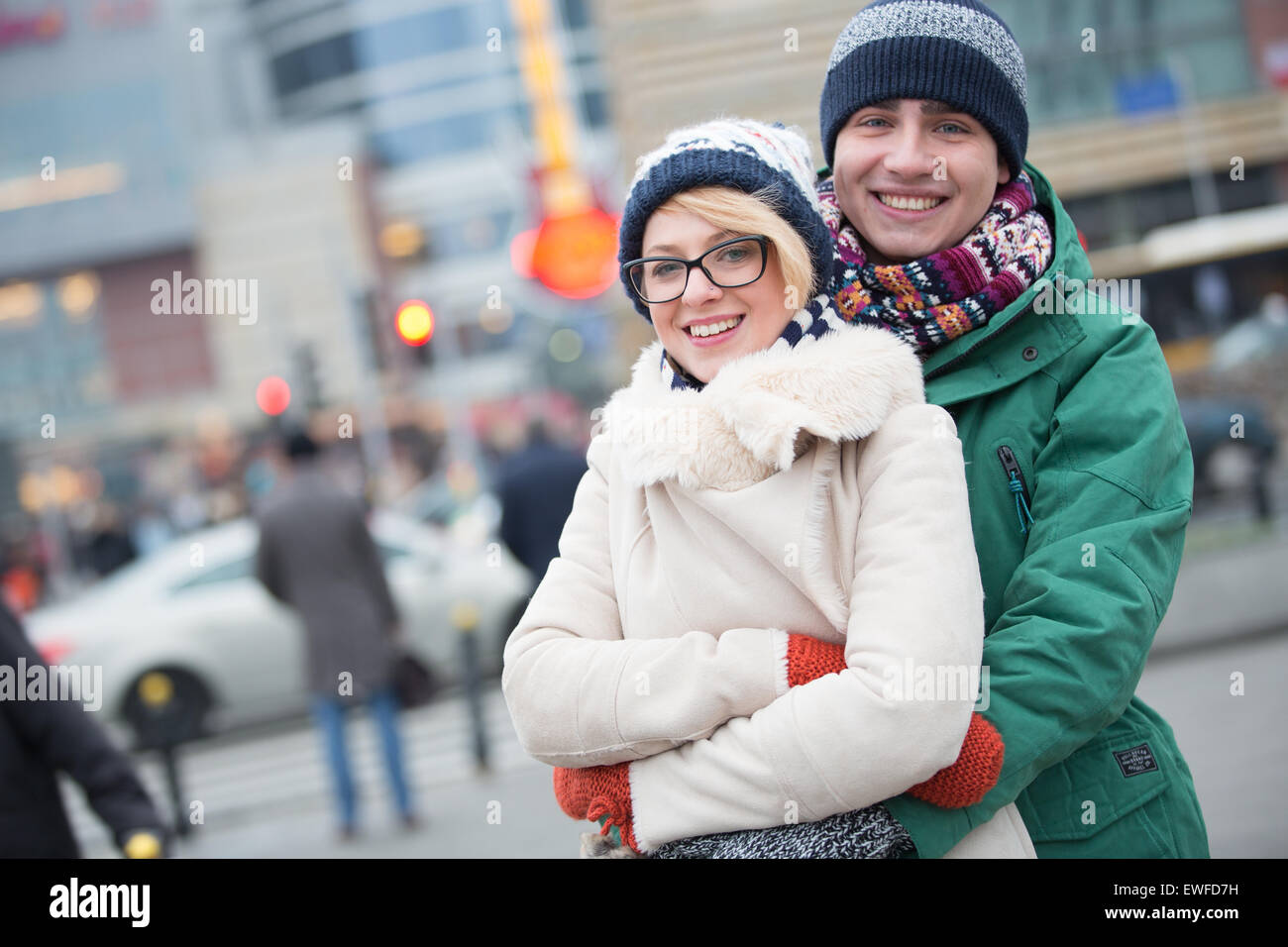 Portrait of happy couple embracing on city street en hiver Banque D'Images