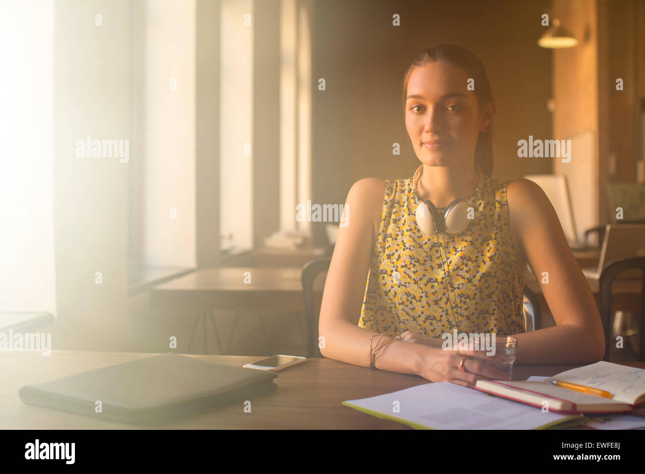 Portrait femme occasionnels avec des écouteurs working in office Banque D'Images