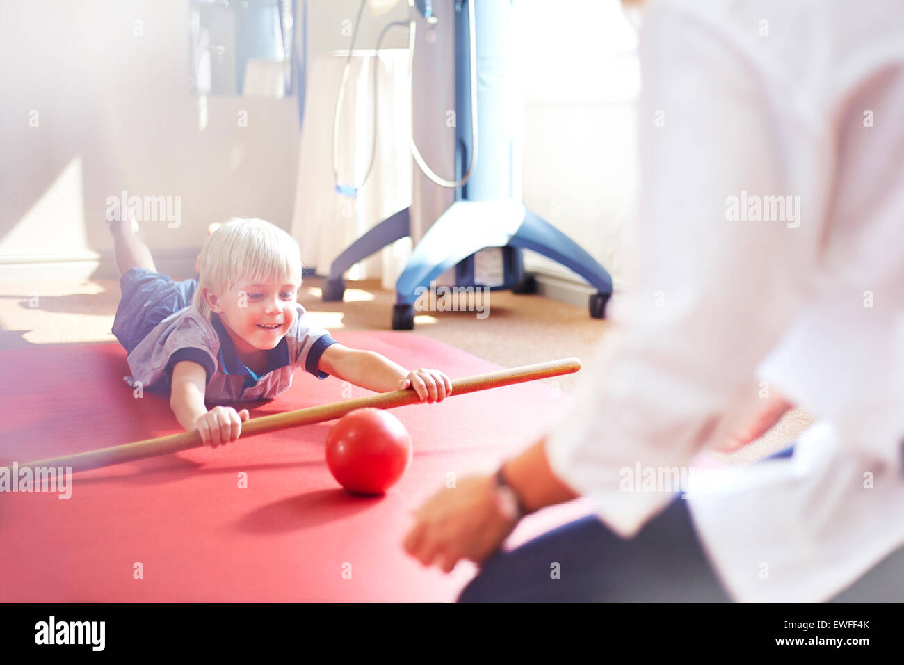 Thérapeute physique rolling ball boy directeurs avec stick Banque D'Images