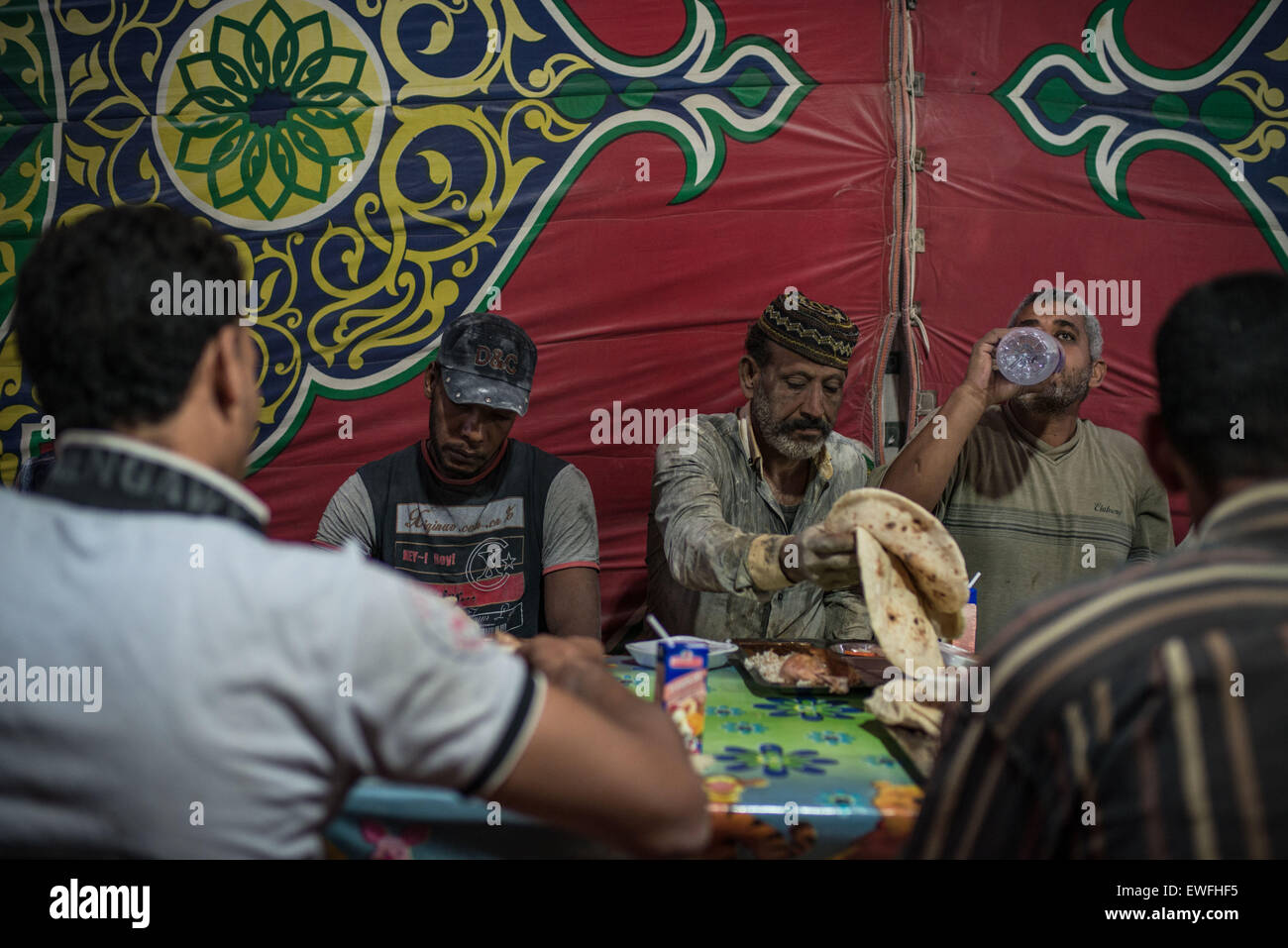 Le Caire, Égypte. 24 Juin, 2015. Les Musulmans égyptiens ont le repas de rupture de l'Iftar à un banquet de bienfaisance stand offert par les entreprises chinoises au Caire, Égypte, le 24 juin 2015. La Chine en Egypte Matériel Pierre Association (CESMA) travaille avec l'Association égyptienne pour le développement intégré (ESID) sur l'offre de la charité des banquets et des boîtes d'aliments pour les résidents locaux pendant le mois sacré du Ramadan. CESMA organise des banquets dans la charité quotidienne Ramadan depuis 2012. © Chaoyue Pan/Xinhua/Alamy Live News Banque D'Images