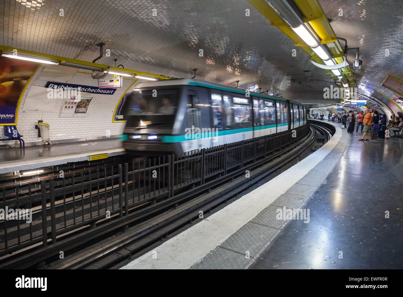 Paris, France - 9 août 2014 : Barbes-Rochechouart. La station de métro parisien avec des passagers et train en mouvement, motion blur effi Banque D'Images