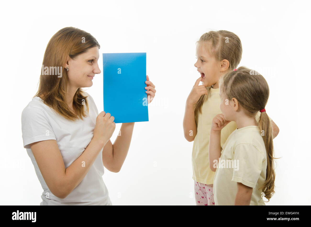 Mère montre deux filles plain d'images couleur, vérifier qu'elles ne distinguer les couleurs Banque D'Images