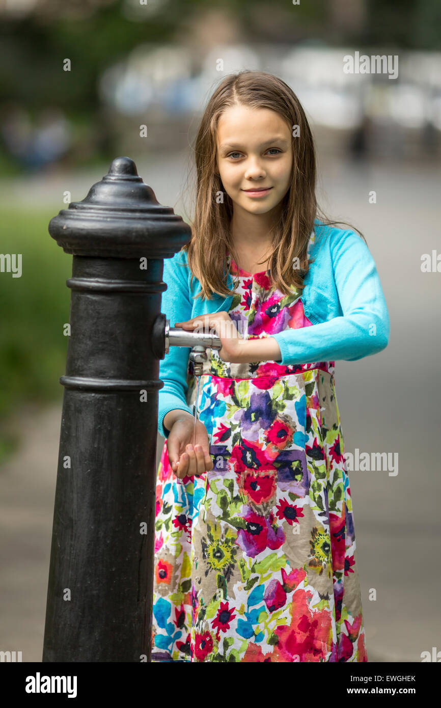 Petite fille mignonne se lavent les mains sous l'eau pompe à main dans la  rue dans la vieille ville Photo Stock - Alamy