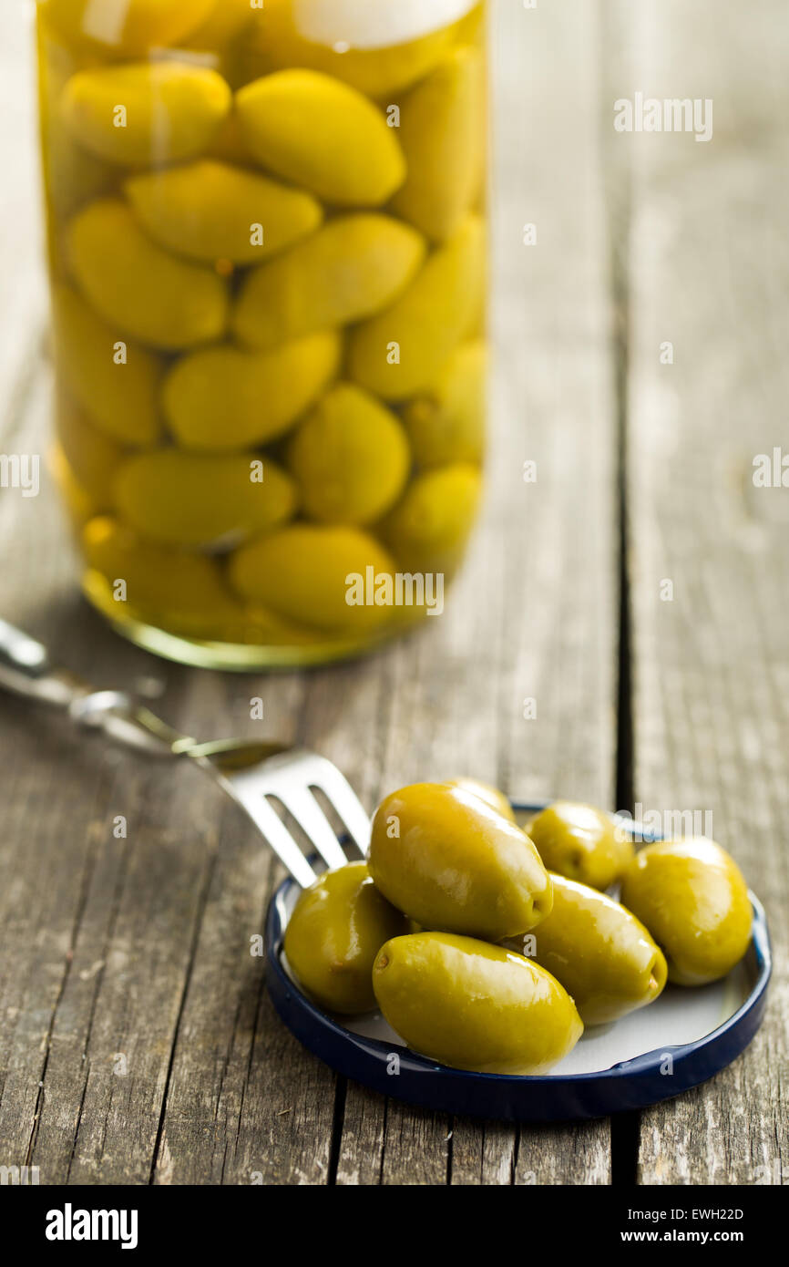 Olives vertes marinées sur l'ancienne table Banque D'Images