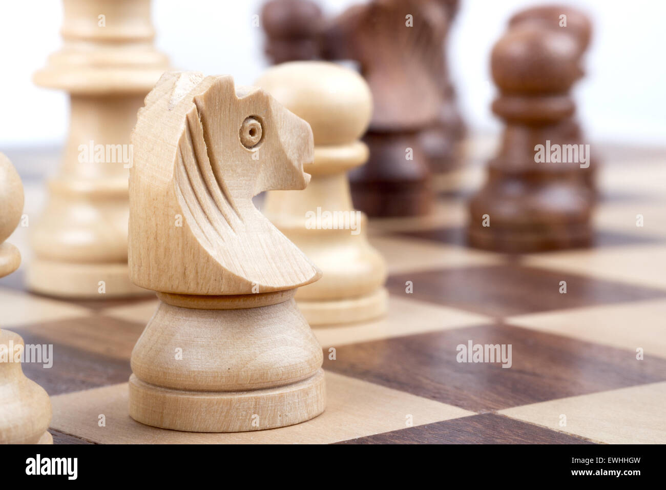 Pièces des échecs pendant sur un échiquier. Banque D'Images