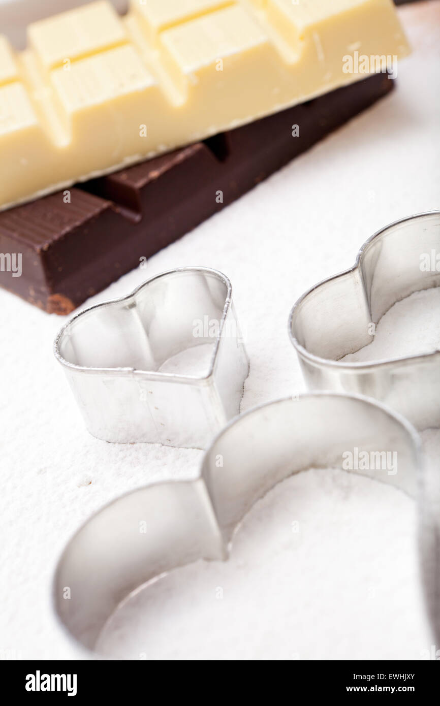 Emporte-pièce et couverture chocolat blanc et noir sur le tapis de cuisson farinée Banque D'Images