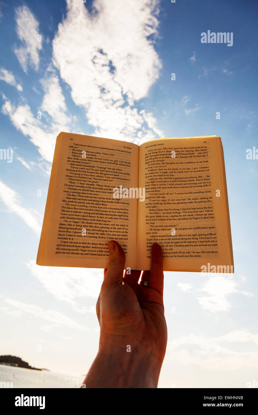 Livre de lecture main contre sky 50 nuances Freed (attention gros mots) Espagnol Espagne Ibiza resort beach maison de vacances lire Banque D'Images
