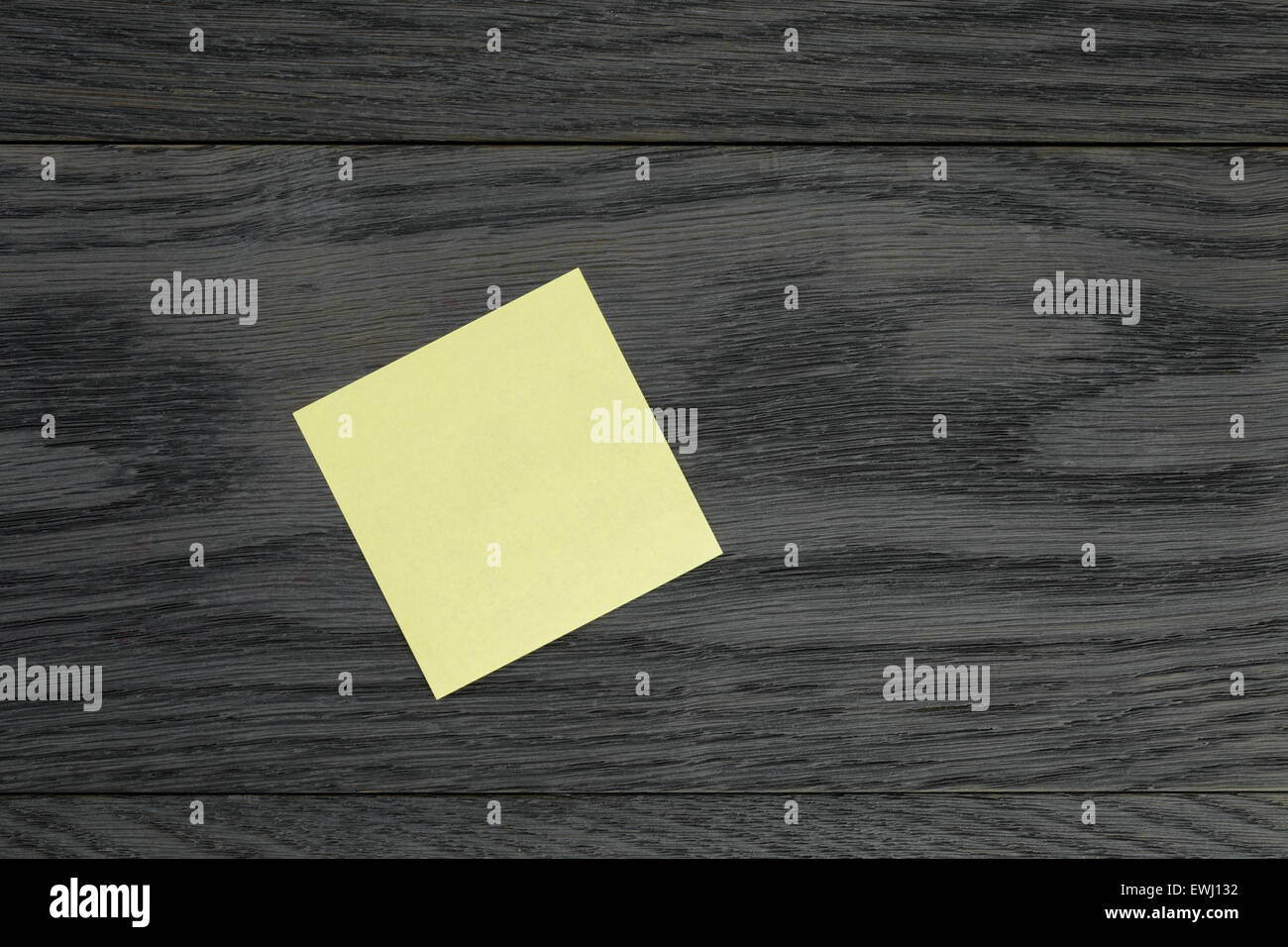 Yellow sticky note on wooden table Banque D'Images