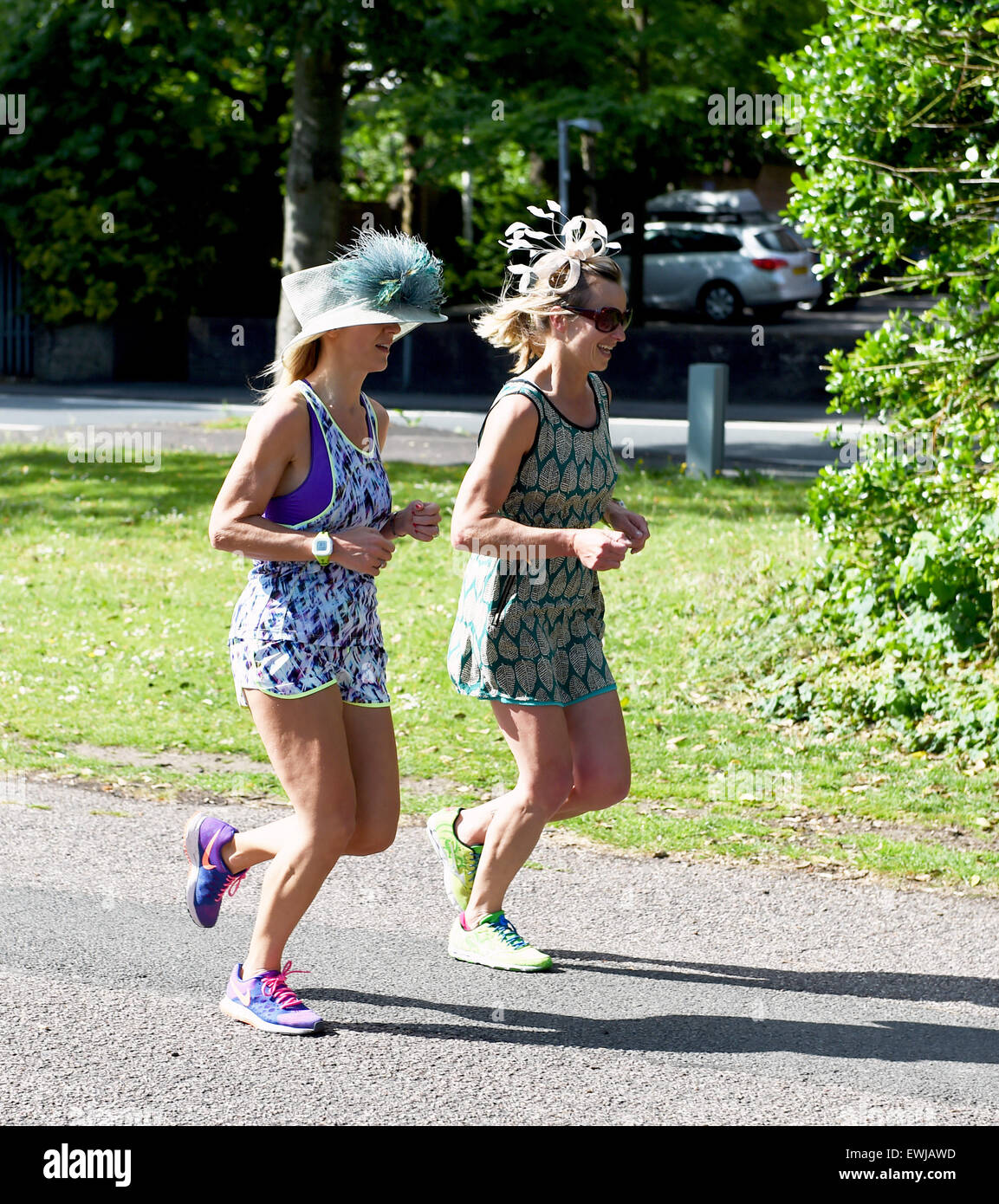 Brighton, Sussex, UK. 27 Juin, 2015. Deux jeunes femmes portant des chapeaux de mariage rendez-vous tôt le matin pour courir à Preston Park Brighton ce matin avec l'ensemble de prévisions météorologiques à être chaud toute la journée et des températures qui atteignent le faible 20s c . Peut-être les chapeaux étaient portés à les protéger du soleil Crédit : Simon Dack/Alamy Live News Banque D'Images