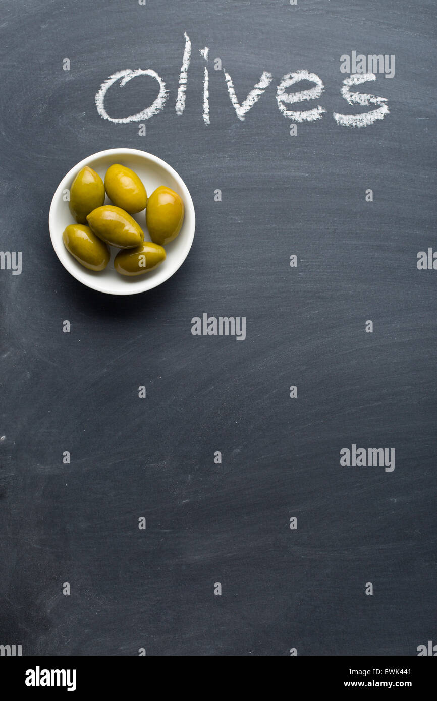 Les olives vertes sur tableau noir Banque D'Images