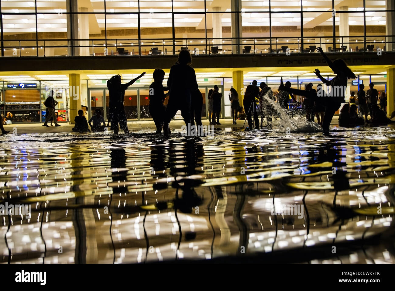 Silhouette enfants jouant dans les fontaines d'eau dans la nuit . Banque D'Images