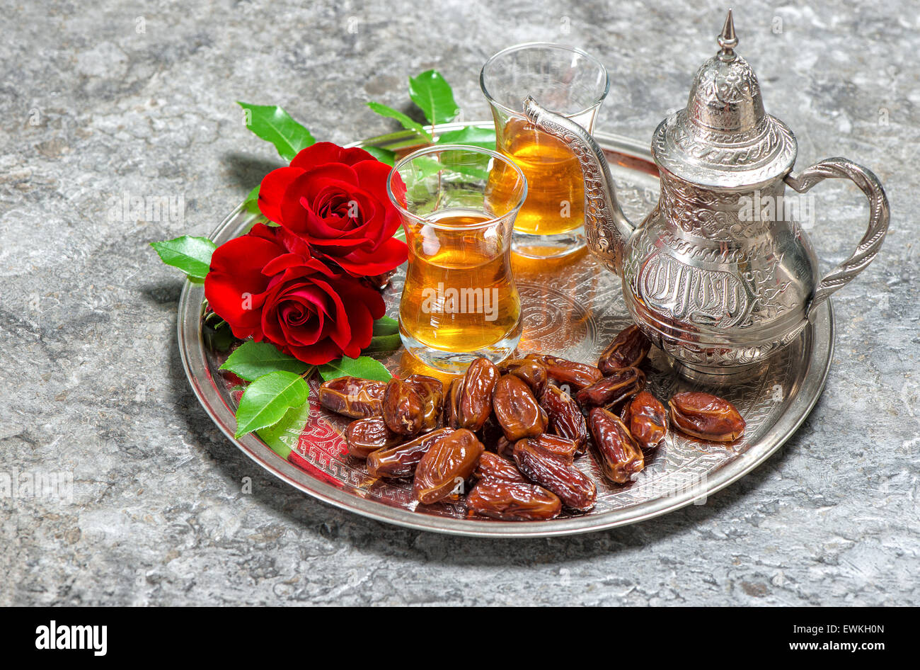 Fleurs rose rouge avec plateau et dates des fruits. Jours fériés islamiques décoration. Ramadan kareem Banque D'Images