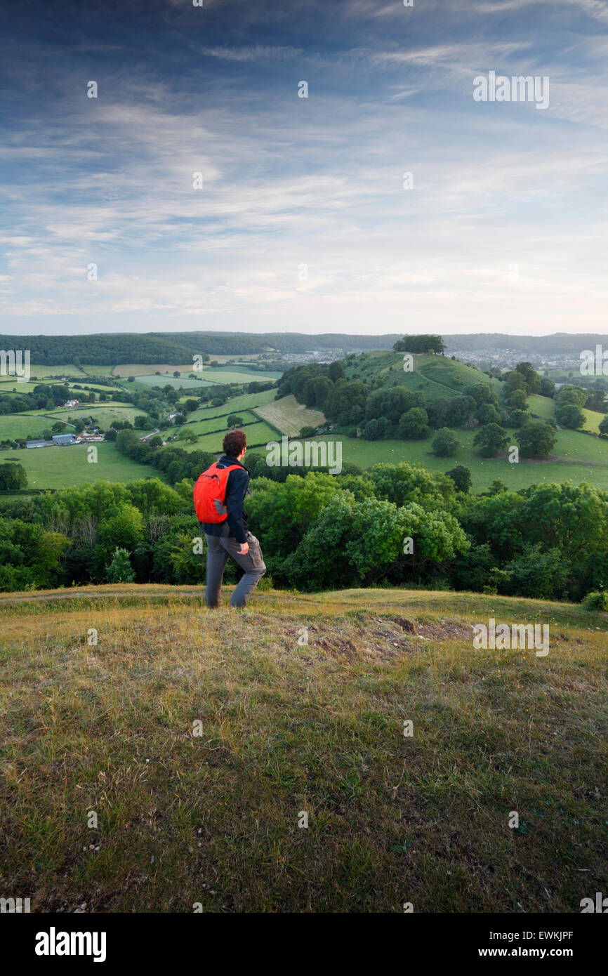 Walker sur Uley Bury, regardant la vue vers M. Downham Hill. Les Cotswolds. Le Gloucestershire. UK. Un petit détour de l'Cotsw Banque D'Images