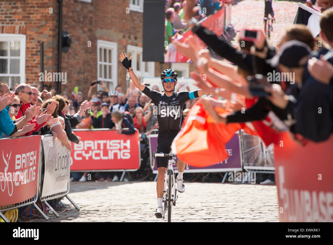 Lincoln, Royaume-Uni. 28 Juin, 2015. Peter Kennaugh (Team Sky) est partiellement masquée par un drapeau de son pays à l'île de Man en tant qu'il remporte le championnat de course route Vélo britannique au Lincoln, Royaume-Uni, le 28 juin 2015. Crédit : Andrew Peat/Alamy Live News Banque D'Images