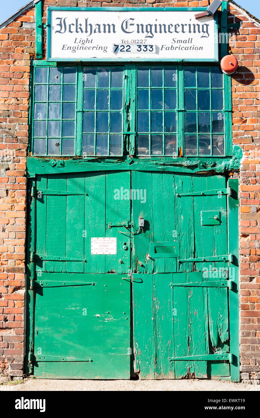 Ickham and well village, Angleterre. Double portes en bois ancien vert de Ickham and Well Engineering Company. Cadre de fenêtres dans la partie supérieure des portes. Banque D'Images