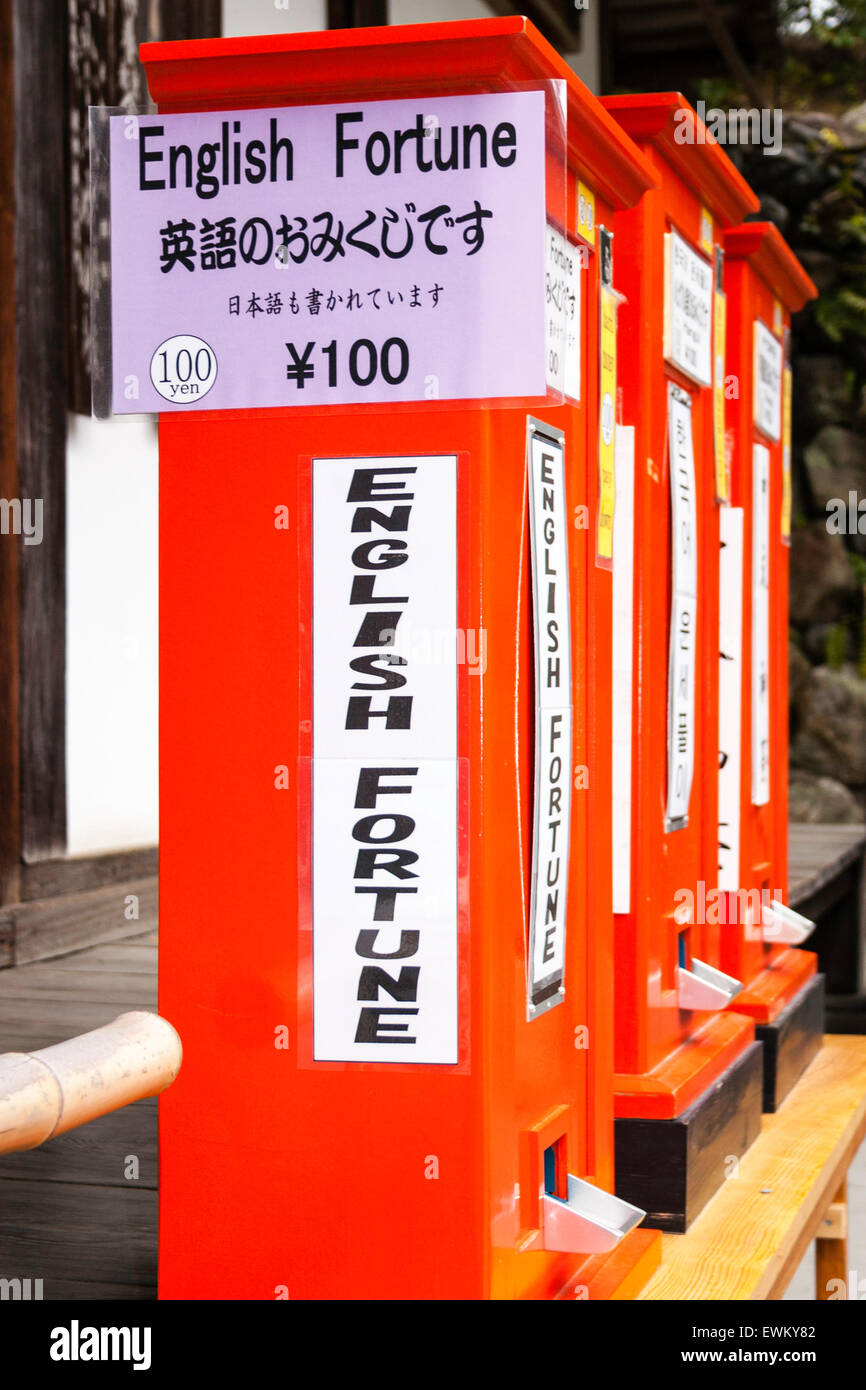 Rouge d'une rangée de trois distributeurs automatiques de fortune japonais glisse, o-mikuji au Golden Temple de Kyoto. Panneau indiquant les feuillets seront en anglais. Banque D'Images