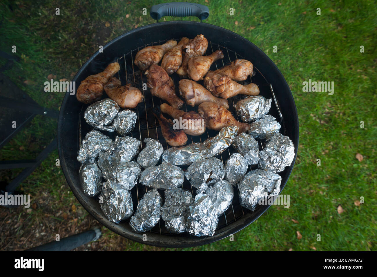 Des pommes de terre et les cuisses de poulet sur le gril, Allemagne Banque D'Images