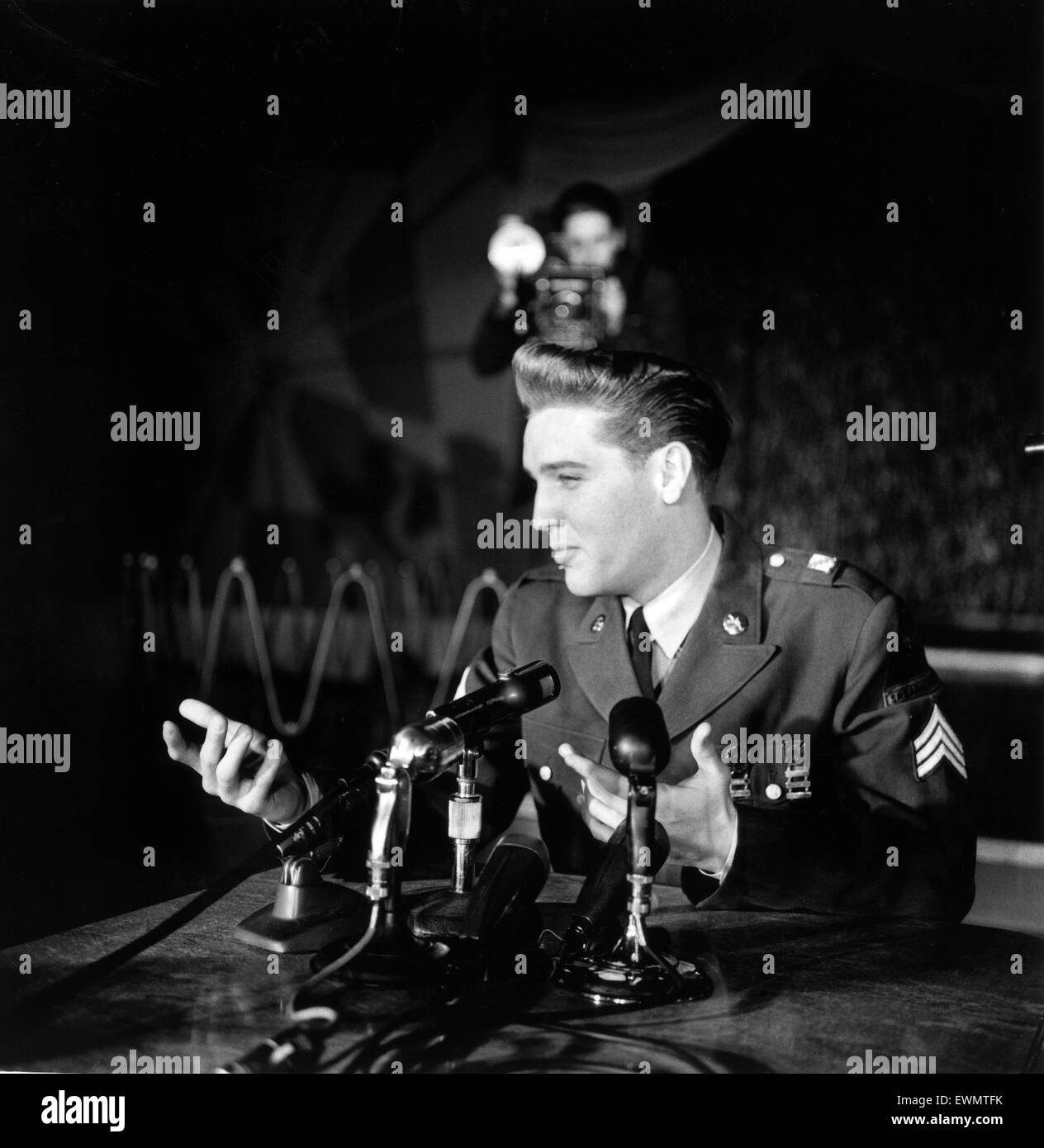 American rock and roll Elvis Presley chanteur et musicien représenté portant des uniformes de l'armée qu'il assiste à une conférence de presse en Allemagne. Mars 1960. Banque D'Images