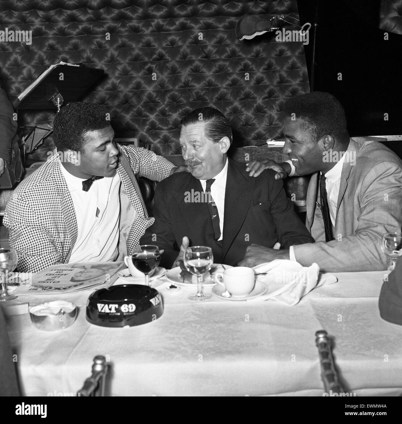 Cassius Clay alias (Muhammad Ali) répond à Peter Wilson (centré) à Isow's restaurant à Soho en avance sur son premier combat avec Henry Cooper. 26 Mai 1963 Banque D'Images
