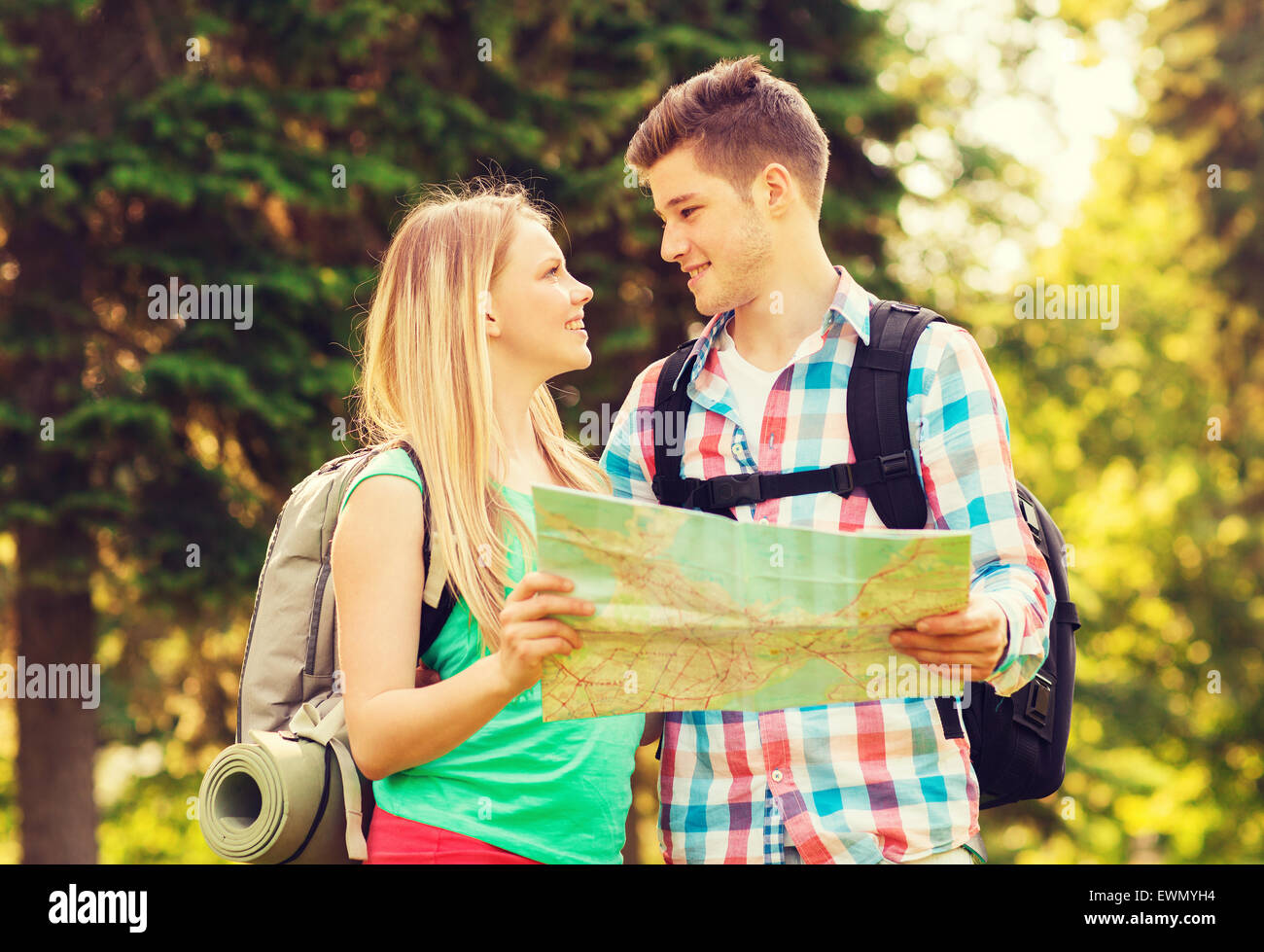 Smiling couple with map et sacs à dos en forêt Banque D'Images