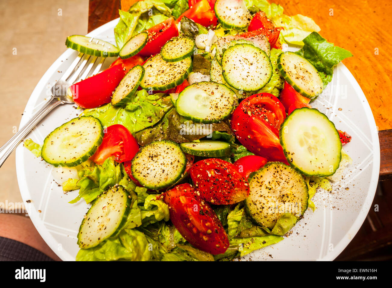 Une simple salade fraîchement faite avec laitue, tomate, concombre et poivre concassé Banque D'Images