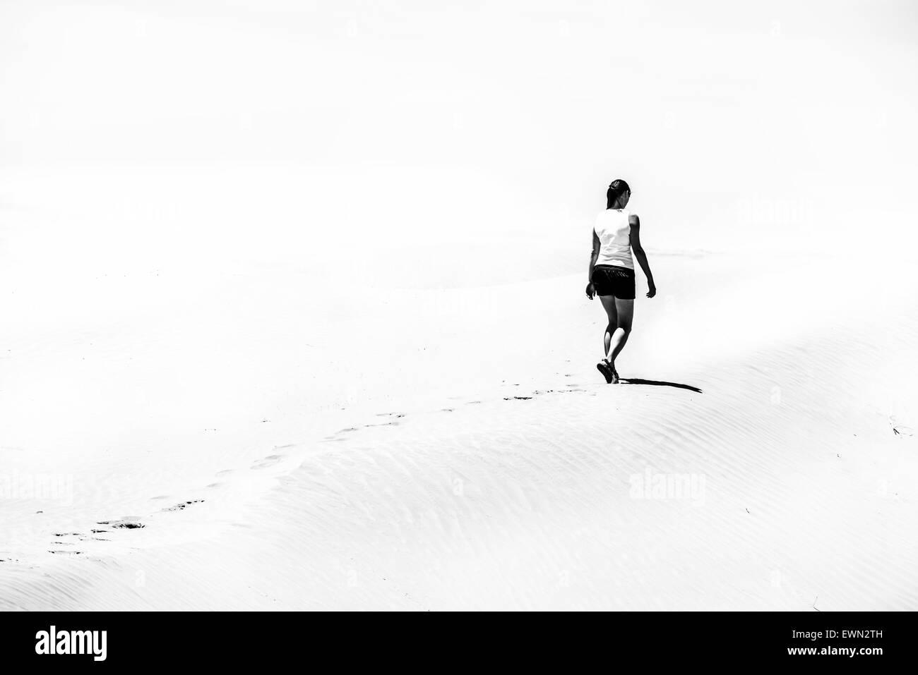 Femme marche sur le désert photo en noir et blanc Banque D'Images