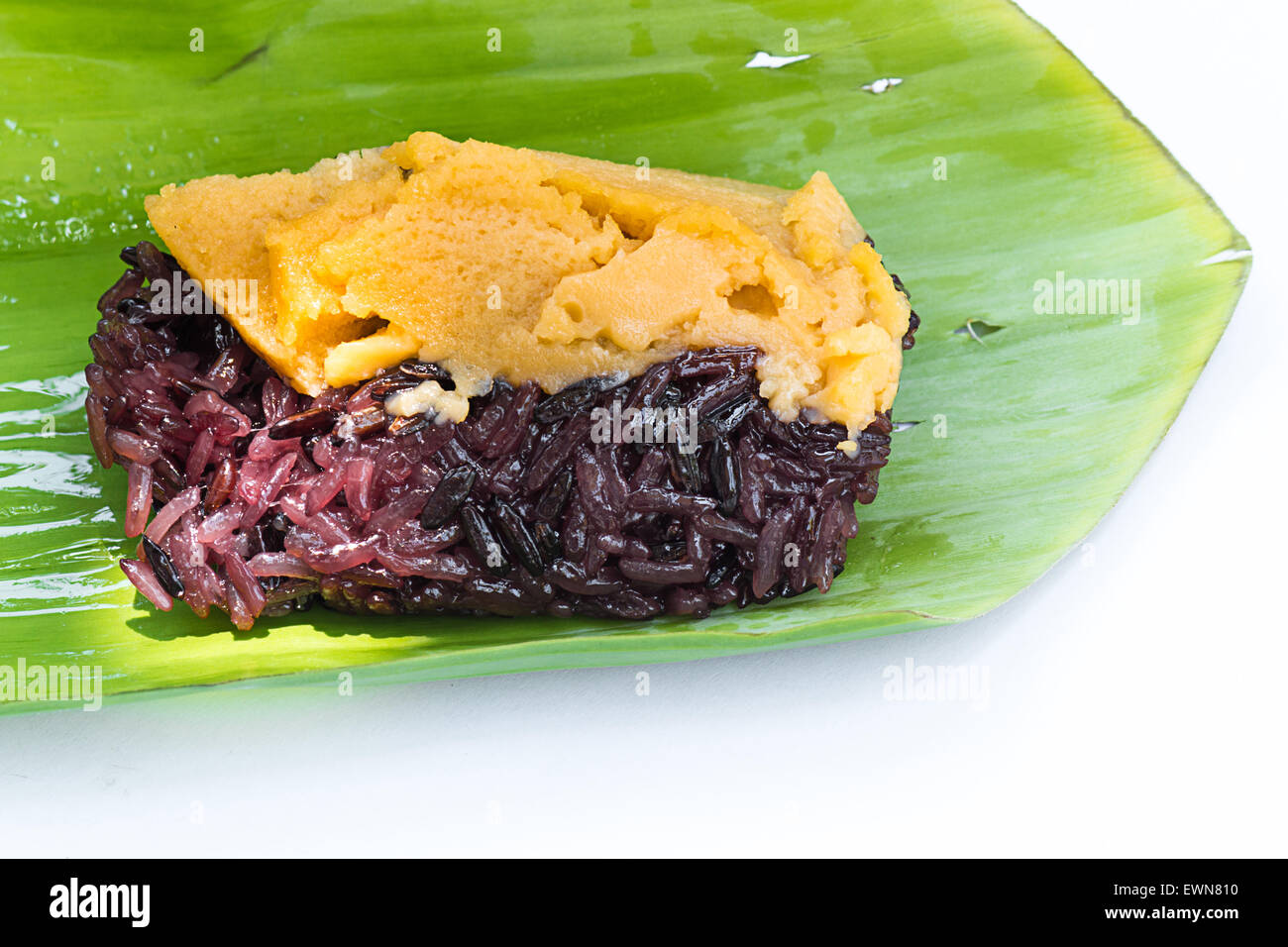 Le riz gluant noir avec de la crème anglaise, enveloppés dans des feuilles de bananier Banque D'Images